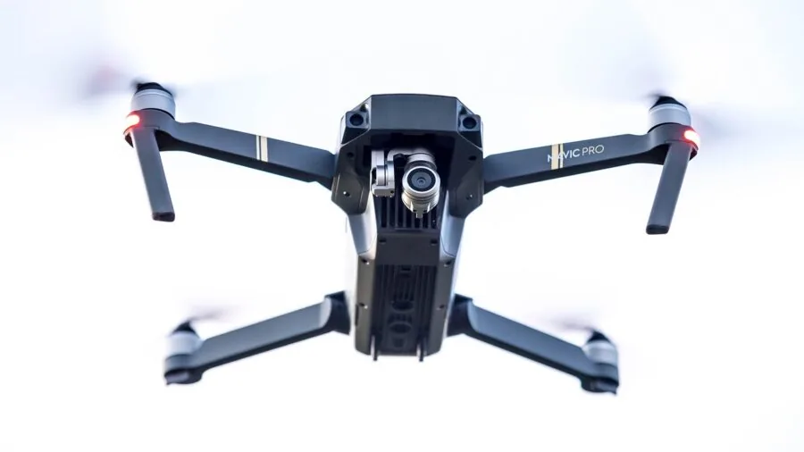 Person opening a drone package outdoors with FPV goggles and components visible