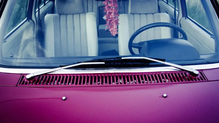 Person opening car door in bright sunlight, demonstrating ease of accessing and storing car accessories