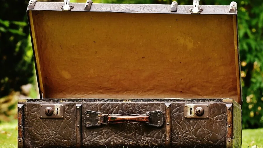Person opening hardside luggage at home after trip, examining contents and condition