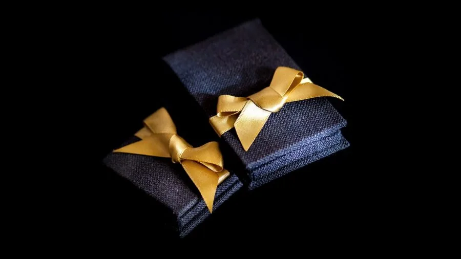 Person opening luxury gift box with elegant wrapping and presentation for special occasion