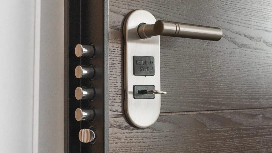 Person opening wooden door with quality hardware in modern home entryway
