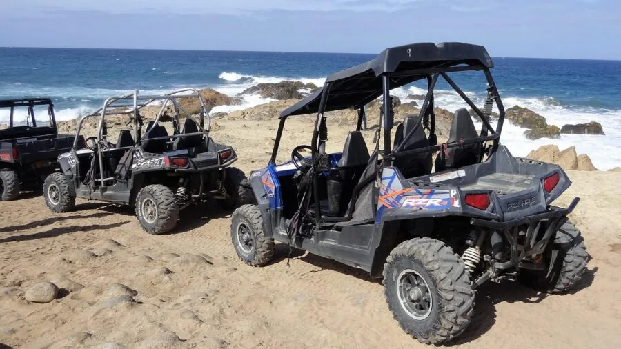 Person operating ATV on rocky mountain trail during outdoor adventure