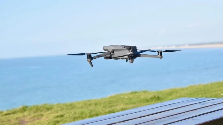 Person operating RC plane in open field with focus and concentration during flight