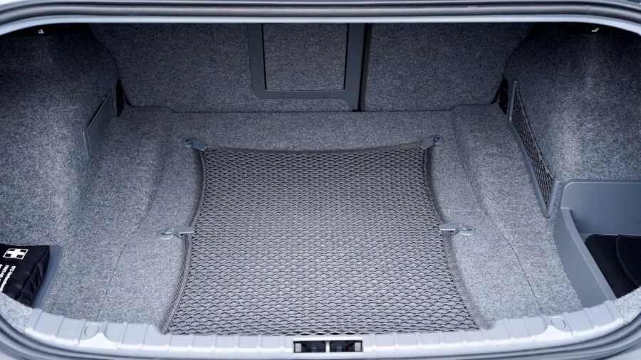 Person organizing car trunk with storage containers and compartments