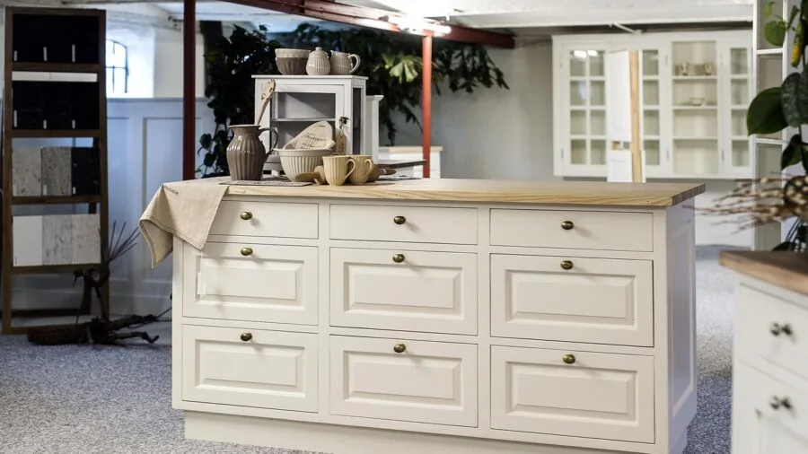 Person organizing clear storage containers and trays in a bright kitchen cabinet