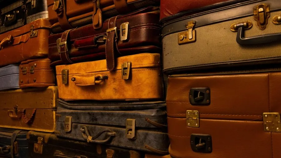 Person organizing clothes and items into an open suitcase while preparing for travel