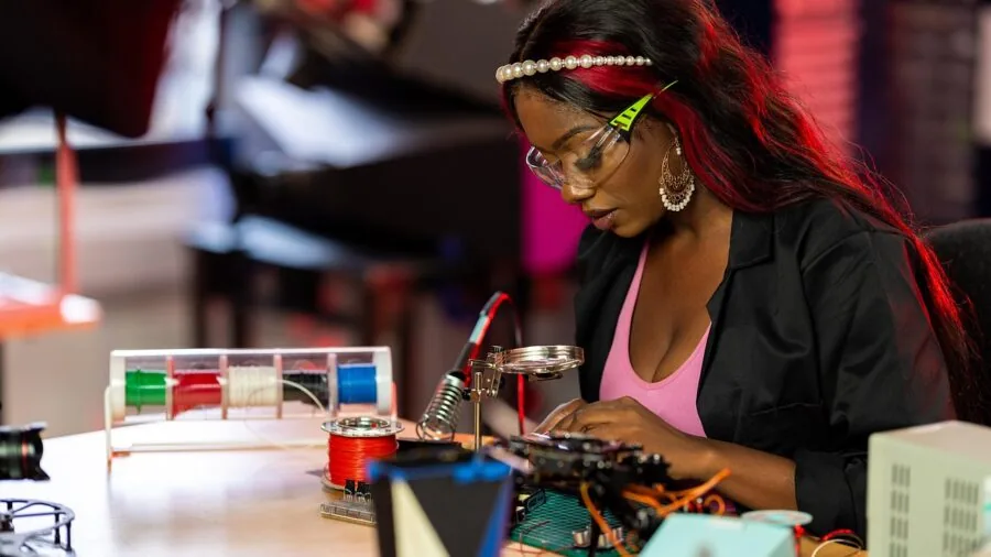 Person organizing colored wires and cables on workbench during electronics repair project
