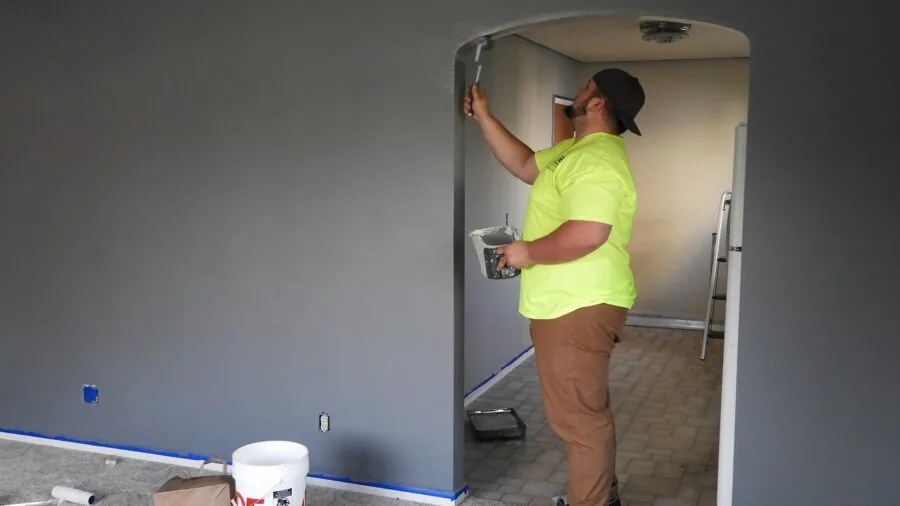 Person organizing painting supplies and tools before starting a home interior painting project