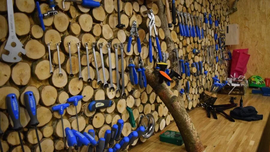 Person organizing tools on workshop wall for efficient workflow and storage