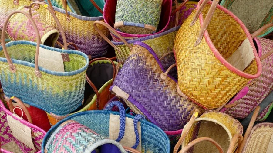 Person organizing wet beach equipment in mesh bag near ocean for air drying and storage