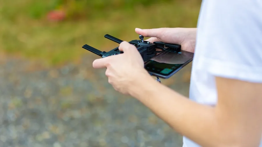 Person outdoors practicing RC helicopter flight controls with focused concentration
