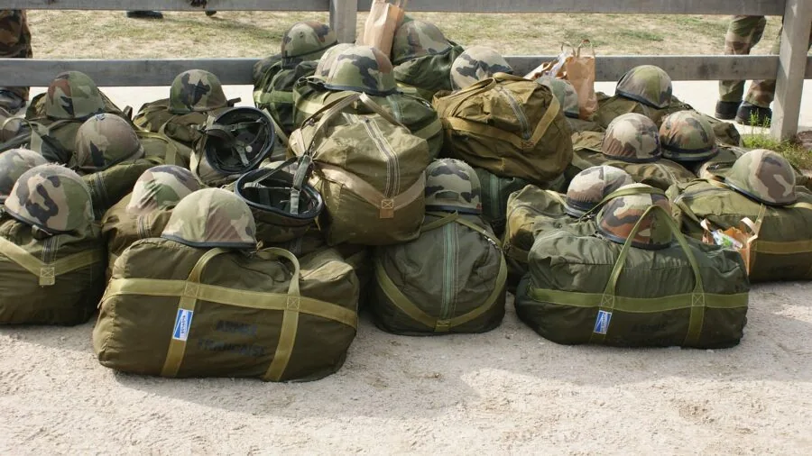 Person packing compact toiletries and travel essentials into a small bag for a trip