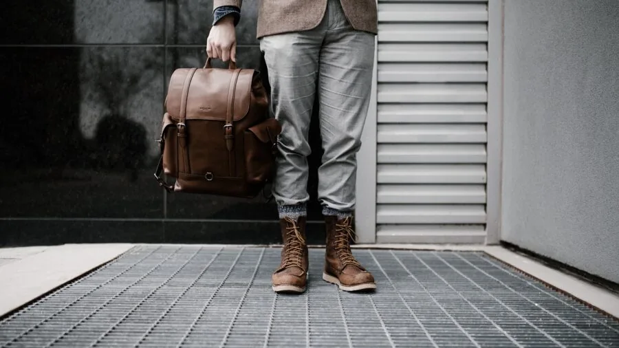 Person packing laptop and tech accessories into a bag for travel