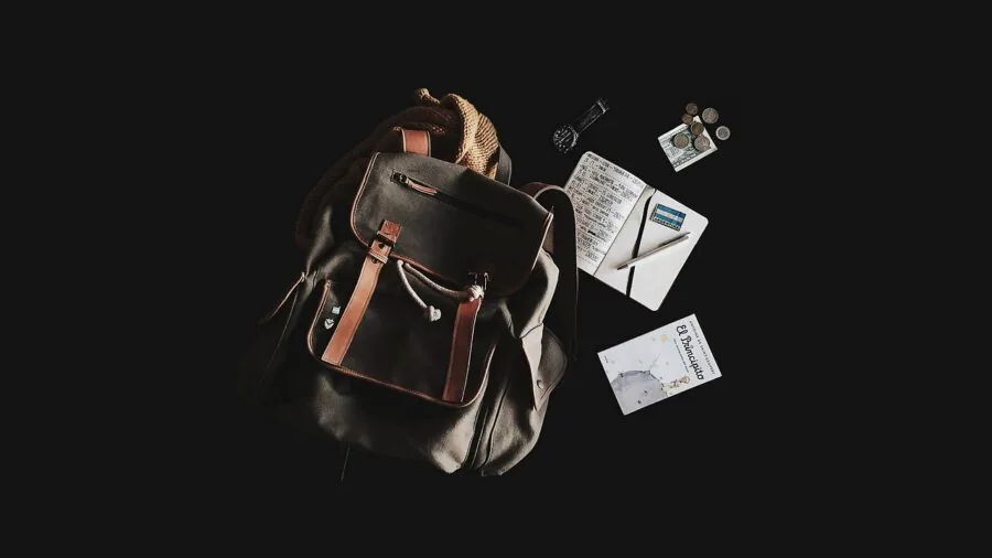 Person packing laptop safely in protective backpack compartment during travel