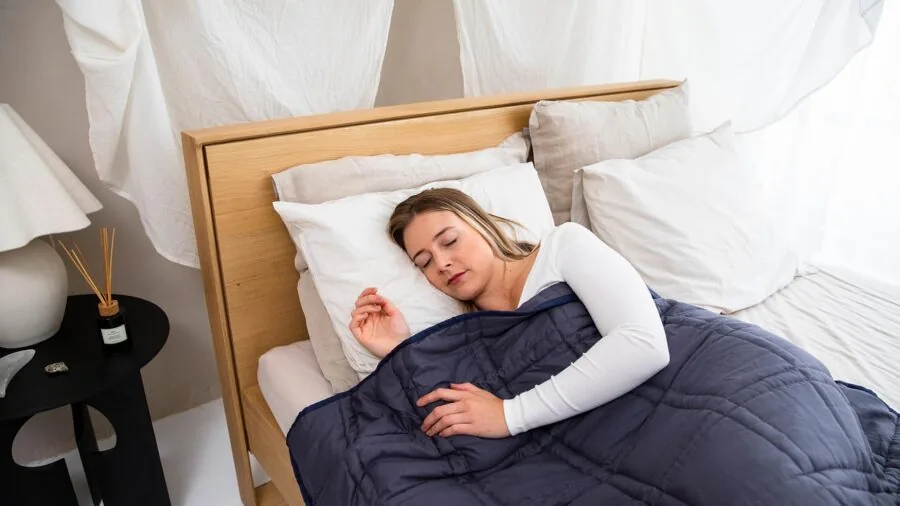 Person peacefully sleeping on white cotton bedsheets, demonstrating breathable natural fabric comfort