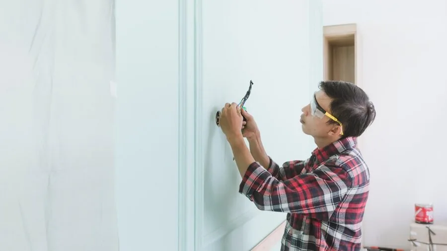 Person performing DIY vehicle maintenance in home garage setting with tools