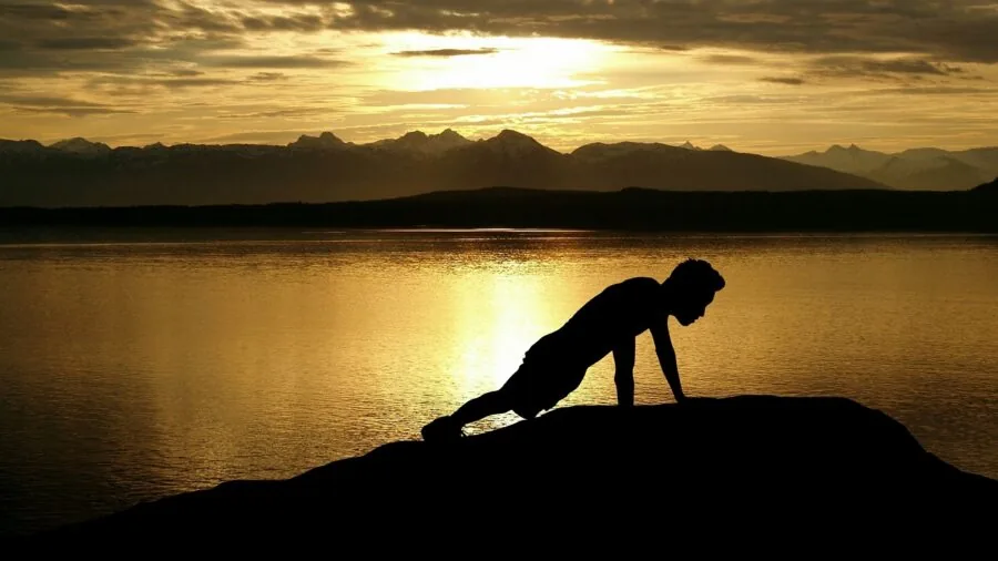 Person performing push-up on stable exercise mat indoors, demonstrating proper form and balance during workout