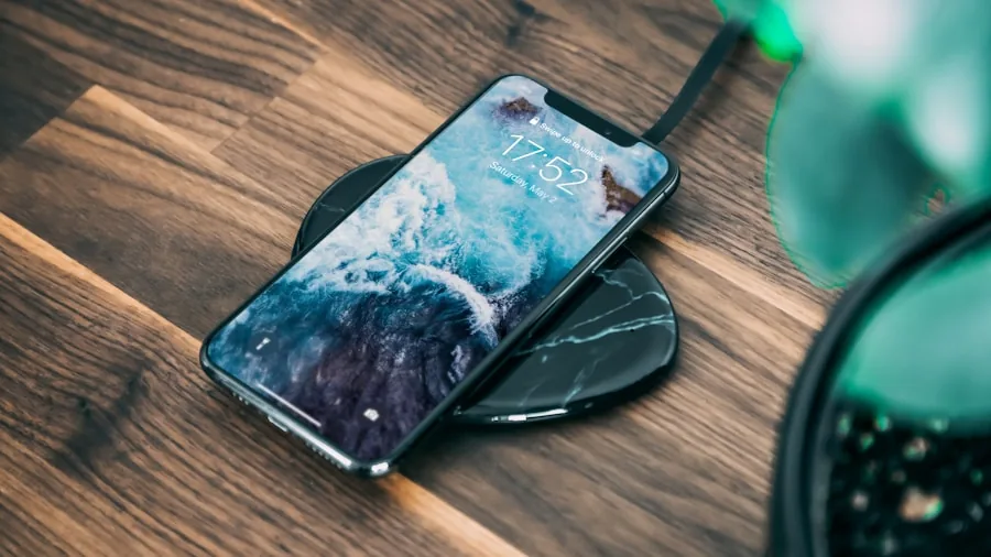 Person placing smartphone on wireless charging pad during daily routine
