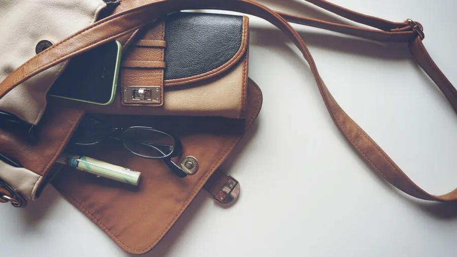 Person placing thin minimalist wallet into front jeans pocket for comfortable daily carry