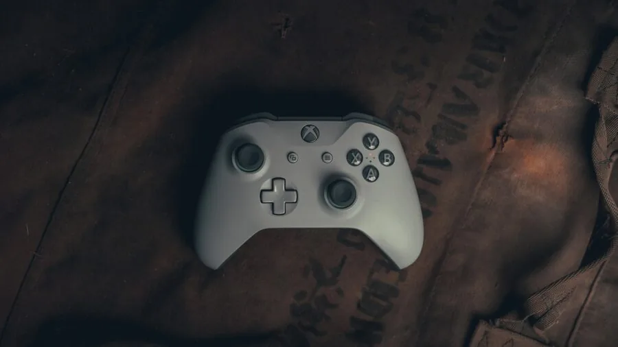 Person playing video game on comfortable gaming setup with controller and monitor