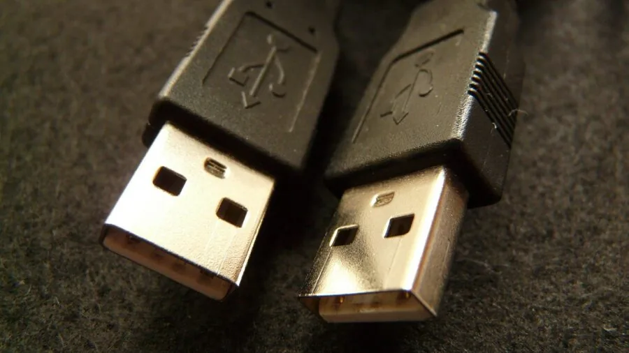 Person plugging USB cable into laptop for data transfer and connectivity