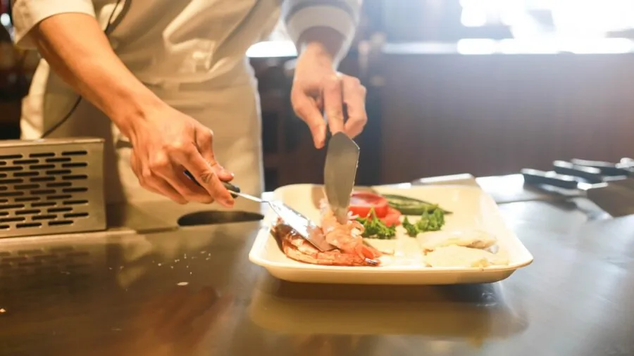 Person preparing a smoothie in a bright kitchen with fresh ingredients on counter