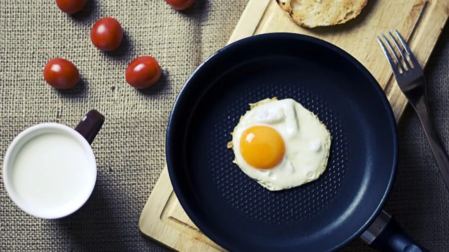 Person preparing breakfast with toast in a bright kitchen, showing real cooking moments and food preparation