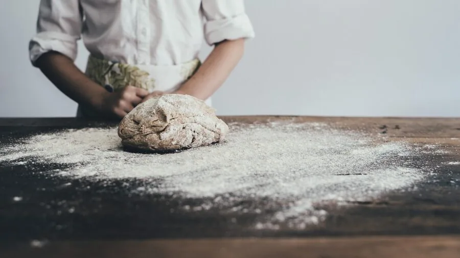 Person preparing healthy food in contemporary kitchen with focus on cooking safety and ingredients