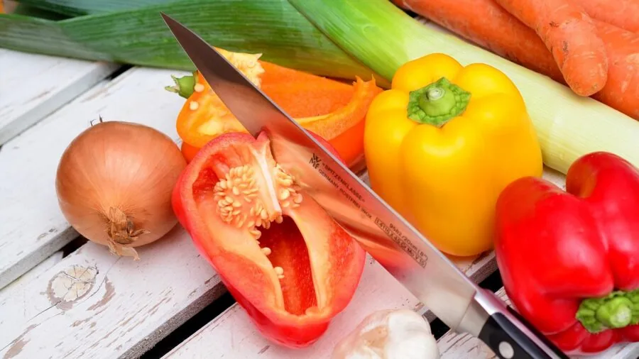 Person preparing vegetables on a budget-friendly cutting board in a home kitchen