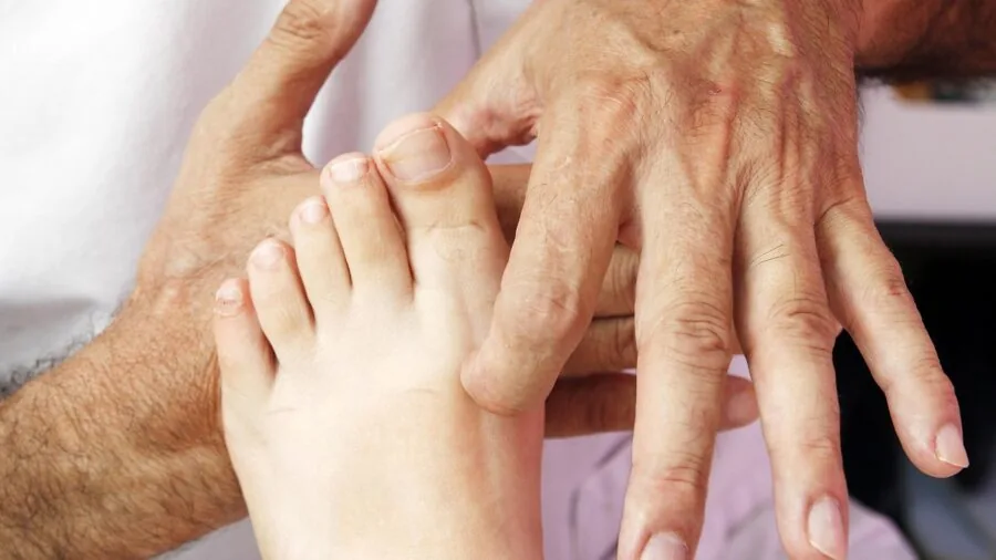 Person receiving a therapeutic foot massage in a comfortable wellness setting
