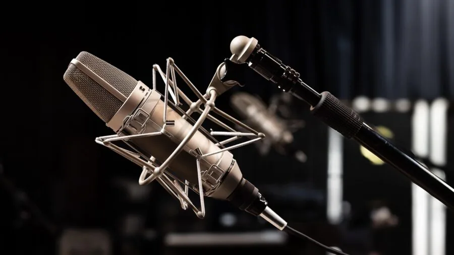 Person recording vocals in home studio with professional microphone and headphones