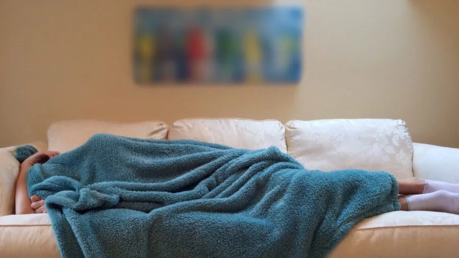 Person relaxing in a calm, quiet living room environment with natural light and comfortable seating