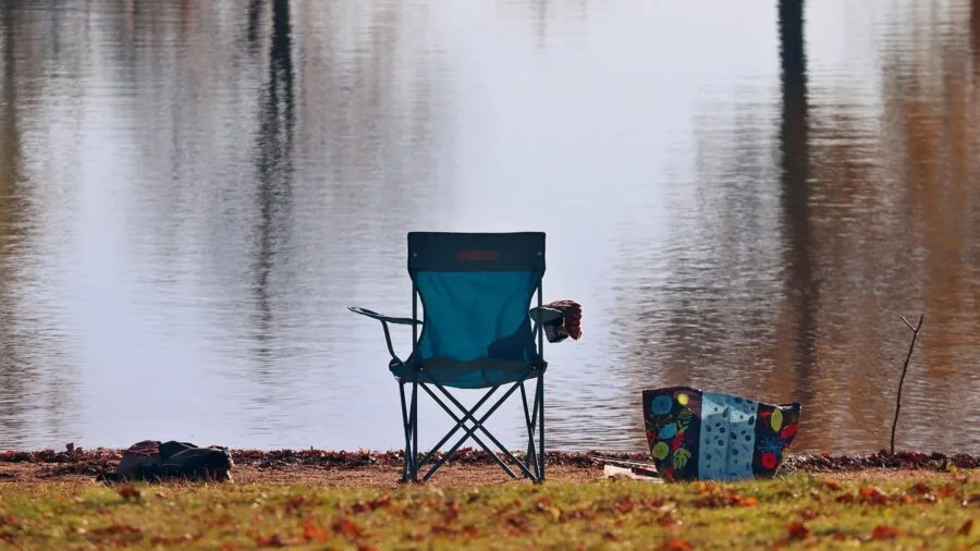 Person relaxing in a camping chair during an outdoor camping trip in nature