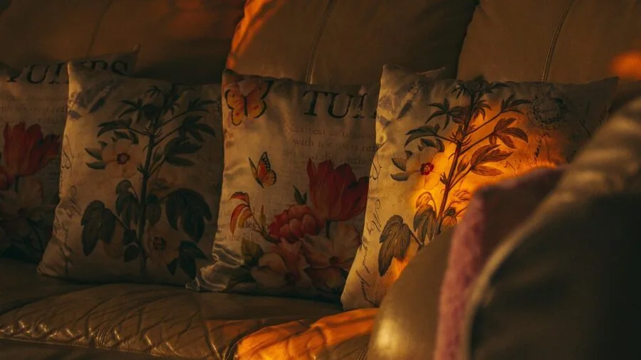 Person relaxing on outdoor sofa with plush cushions in garden setting