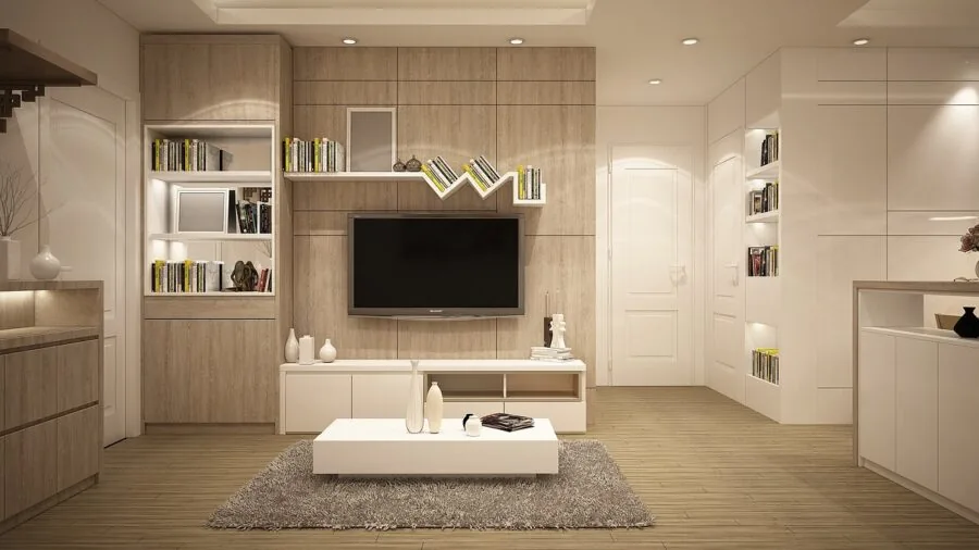 Person relaxing on sofa with organized items in armrest pocket, remote and book nearby