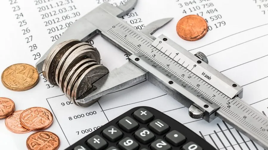 Person reviewing financial documents and comparing costs while planning household budget at desk