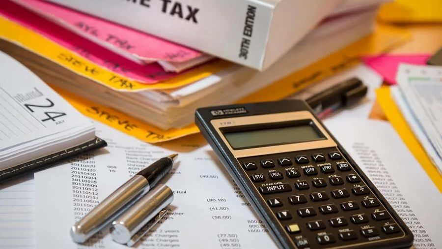 Person reviewing financial documents and planning long-term budget expenses at home desk