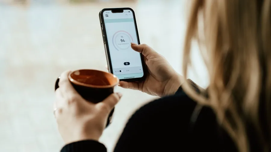 Person reviewing health data on smartphone while sitting at home, representing app-based wellness tracking