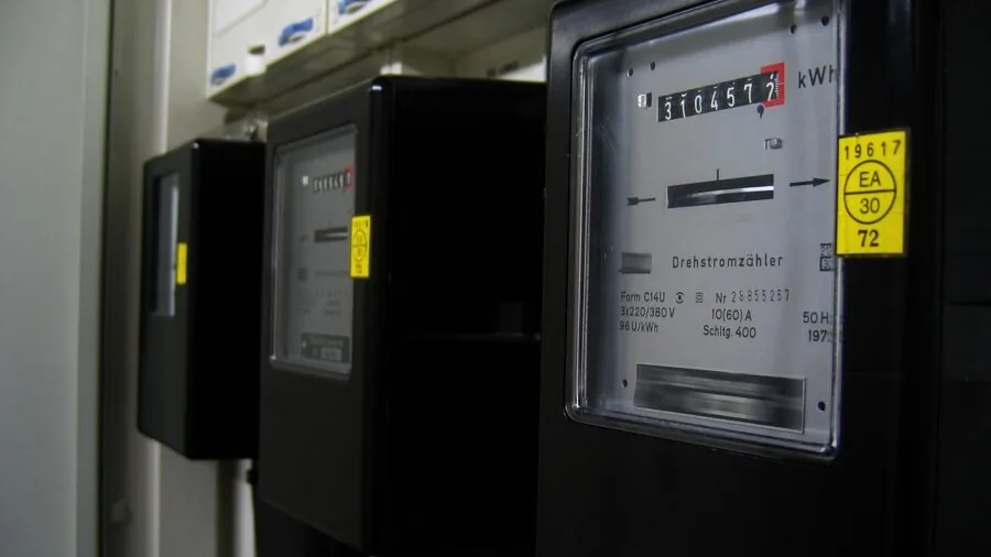 Person reviewing home energy consumption meter to monitor monthly utility costs and efficiency