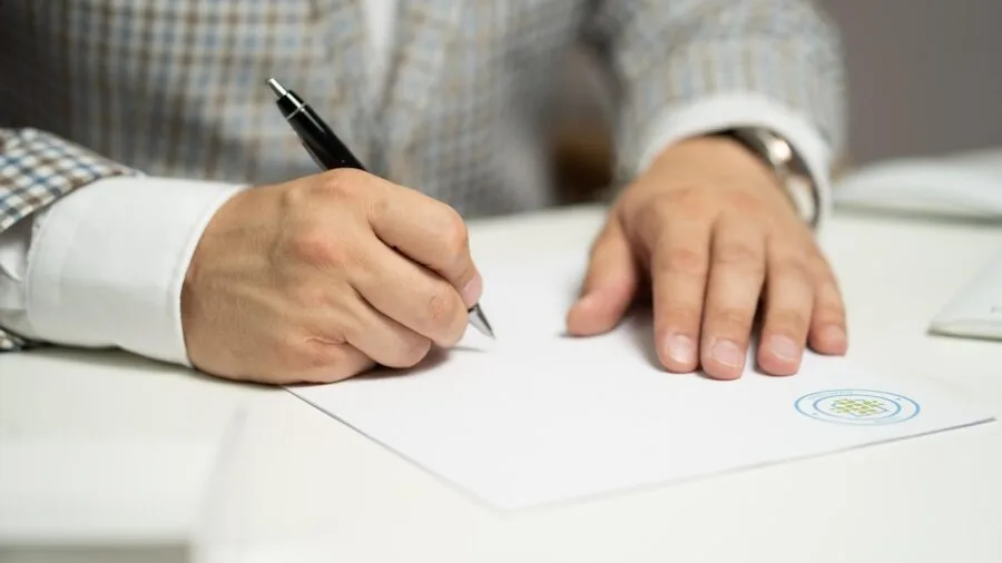 Person reviewing solar panel warranty documentation at home desk with natural lighting