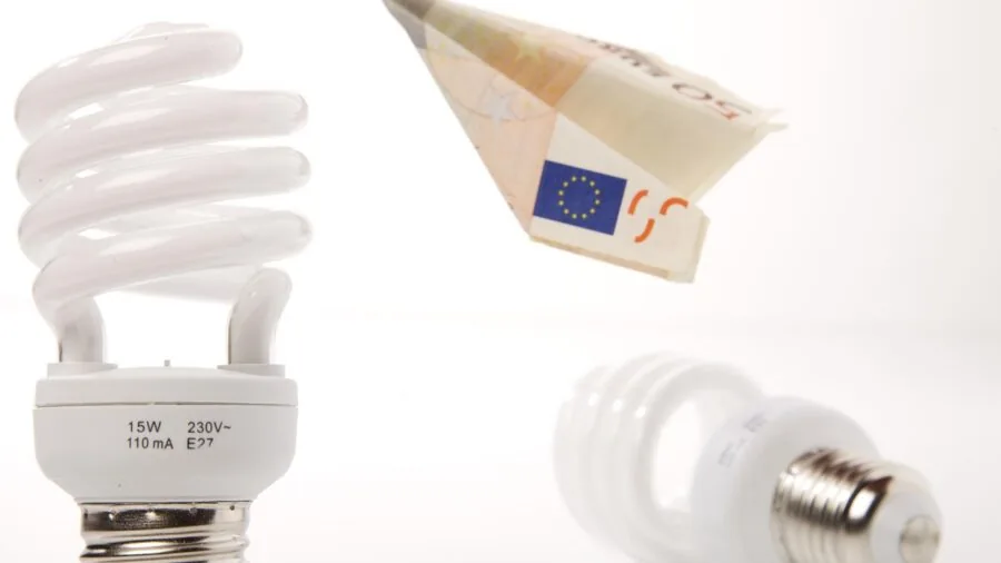 Person reviewing utility bills and expenses at home desk, managing household energy costs