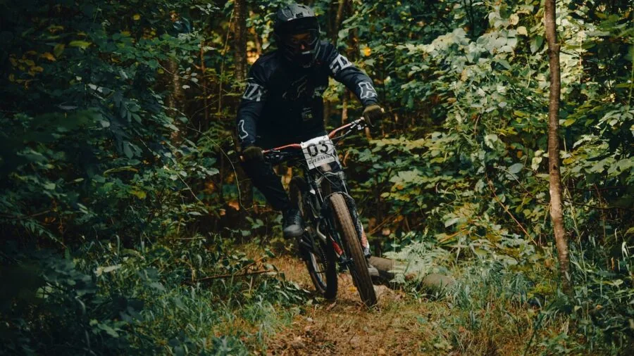 Person riding bicycle on outdoor trail with natural scenery