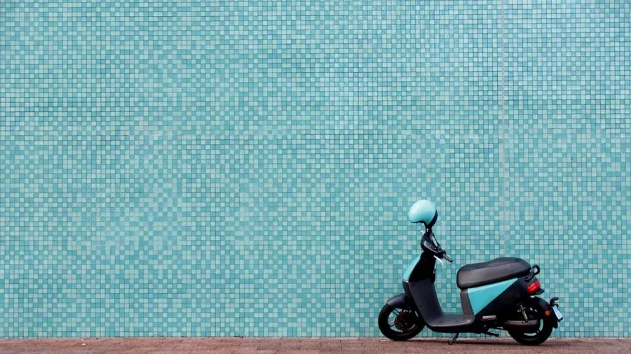 Person riding scooter on urban street with natural lighting and realistic road conditions