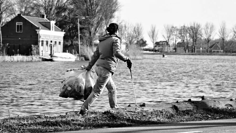 Person scooping cat litter from a litter box during routine pet care and cleaning