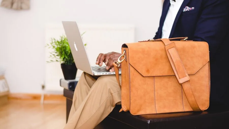 Person seated in ergonomic office chair at desk in modern workspace
