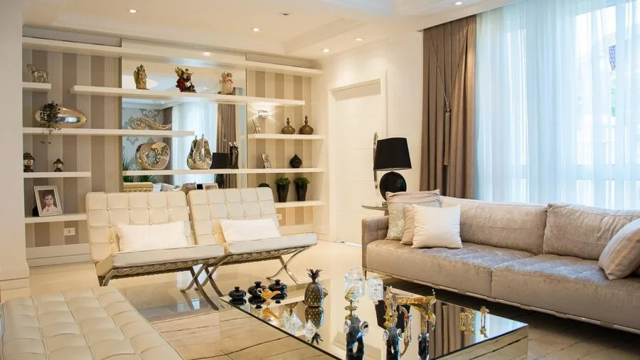 Person selecting and arranging decorative pillows on a comfortable sofa in a modern living room