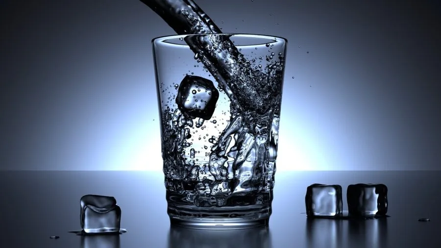 Person selecting and pouring beverages into different sized drinking glasses on a kitchen counter