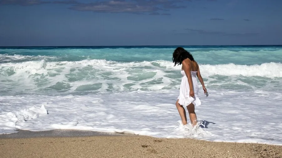 Person selecting towel size for beach use, demonstrating practical towel selection
