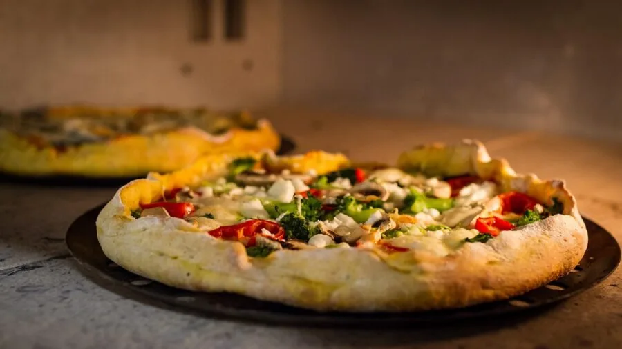 Person setting up a portable pizza oven in a backyard outdoor entertaining space