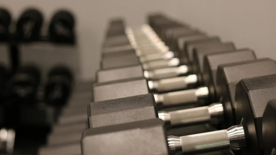 Person setting up affordable workout equipment in home gym space